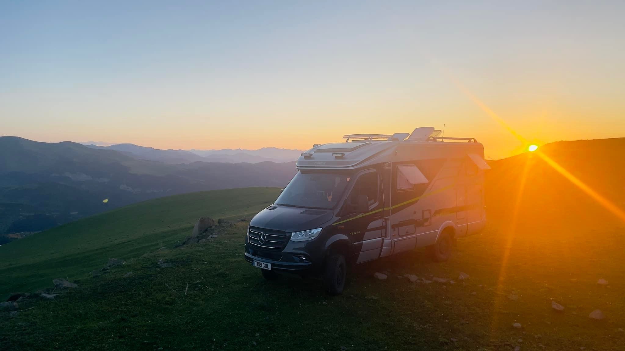Motorhome parked on a mountain at golden sunrise